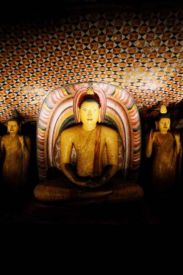 Entrance and painted interior of the Dambulla Cave Temple showing ancient Buddhist murals and statues