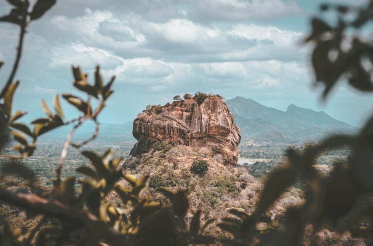 Sunrise view of Sigiriya Rock fortress from the summit of Pidurangala Rock with misty valleys below