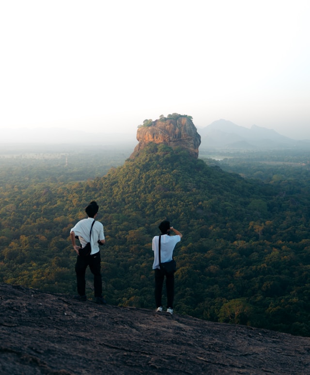 Sunrise view of Sigiriya Rock fortress from the summit of Pidurangala Rock with misty valleys below
