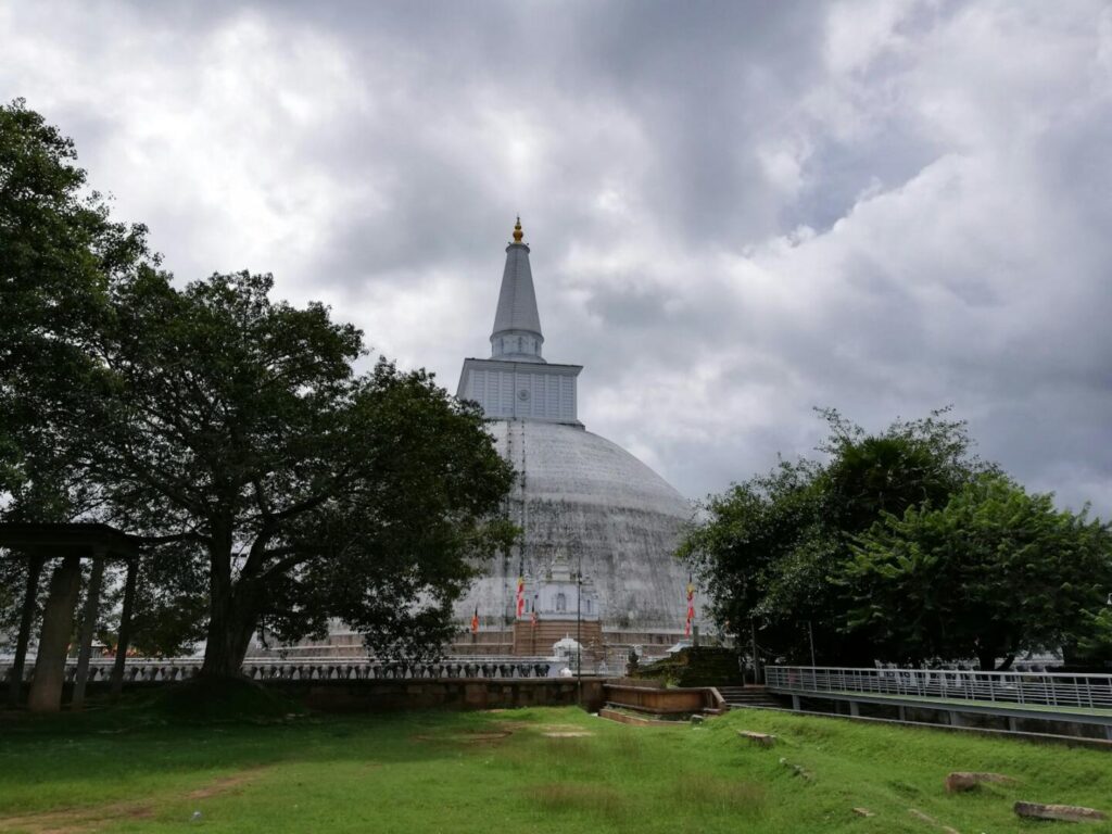 Evening view of illuminated ancient stupa at Anuradhapura with oil lamps glowing — supporting travel image 2