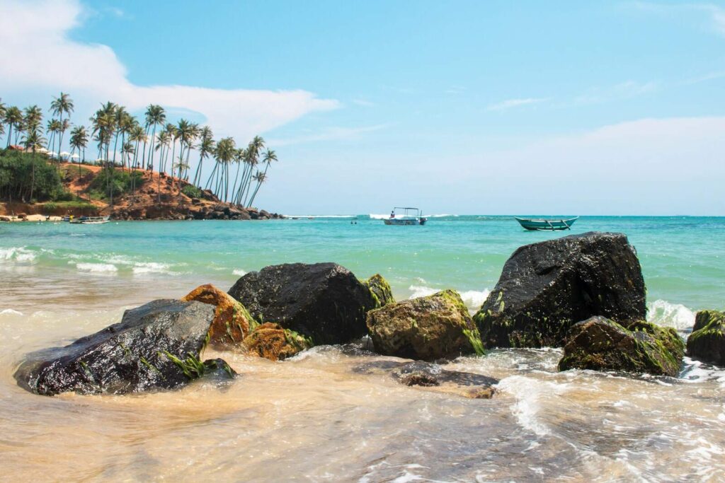 View of a golden sandy beach in Sri Lanka with palm trees and clear blue water — supporting travel image 2