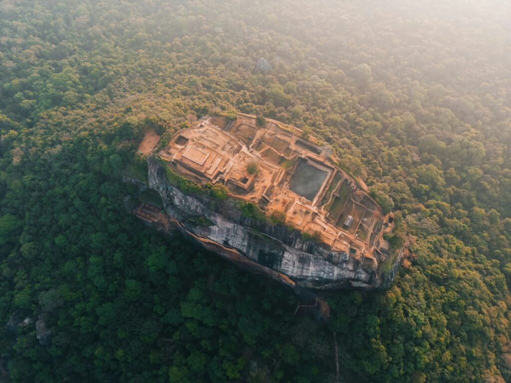 View of Sigiriya Lion Rock fortress rising above the lush Sri Lankan landscape at sunrise — supporting travel image 2